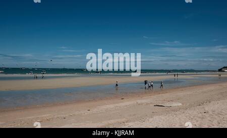 La gente camminare sulla sabbia della bassa marea la spiaggia di Pattaya Thailandia del sud-est asiatico Foto Stock