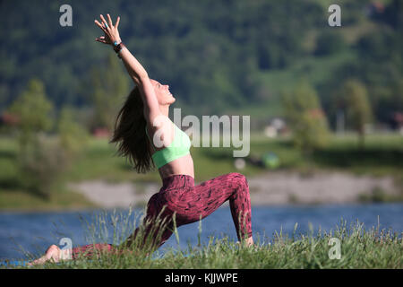 La donna a praticare lo yoga e la meditazione al di fuori. Foto Stock