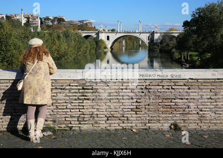 Donna che guarda sul fiume Tevere a Roma. L'Italia. Foto Stock