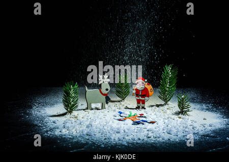 Anno nuovo sfondo. le figure di santa claus, cervi e ragazzo. angelo di neve. nevicava. telaio di notte. billetta per cartoline o congratulazioni. spazio copia Foto Stock