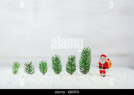 Anno nuovo sfondo. figure di Babbo Natale e cervi. billetta per cartoline o congratulazioni. abeti della foresta tra i cumuli di neve. copia di spazio. Foto Stock