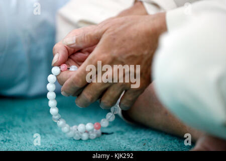 Masjid Al Rahim moschea. Uomo che prega in una moschea con Tasbih (grani di preghiera), Close-up. Ho Chi Minh City. Il Vietnam. Foto Stock