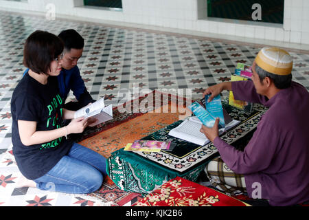 Saigon Moschea centrale. Uomo musulmano dando brochure per una giovane coppia. Ho Chi Minh City. Il Vietnam. Foto Stock