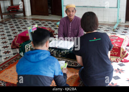 Saigon Moschea centrale. Uomo musulmano dando brochure per una giovane coppia. Ho Chi Minh City. Il Vietnam. Foto Stock