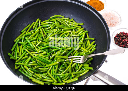 Frittura di baccelli di fagioli verdi in padella. studio foto Foto Stock