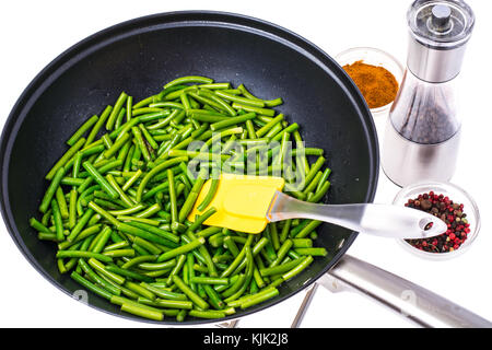 Frittura di baccelli di fagioli verdi in padella. studio foto Foto Stock