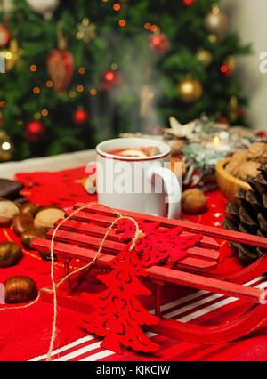 Tazza di tè caldo sulla tavola del Natale con alle spalle di albero di natale. Foto Stock