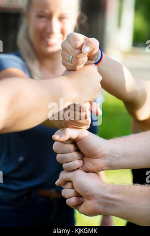 Immagine ritagliata di amici a suon di pugni di impilamento in foresta Foto Stock