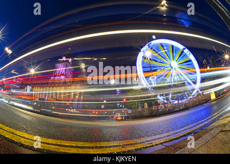 Il traffico che passa luna park e le luci di Natale da leeds town hall al crepuscolo Yorkshire Regno Unito Foto Stock