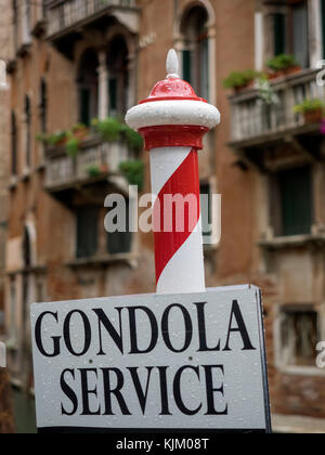 VENEZIA, ITALIA - 12 SETTEMBRE 2017: Tradizionale Polo di ormeggio a strisce con gondola cartello Servizio con edifici tipici sullo sfondo Foto Stock