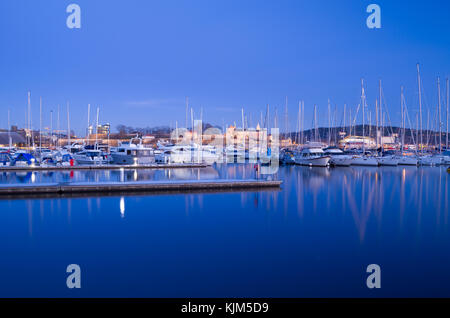 Umore invernale di Aker Brygge marina piena di yacht a pelo, con il castello di Akershus in background, nella calma della sera. Oslo, Norvegia. Foto Stock