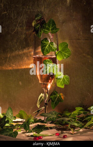 Bicchiere di champagne rosa in vetro vintage con foglie Foto Stock