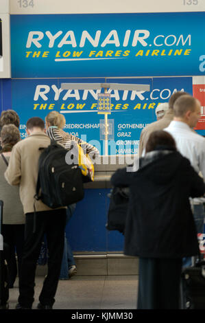 Coda di passeggeri al terminal principale Ryanair check-in piazzale con il bagaglio a mano Foto Stock