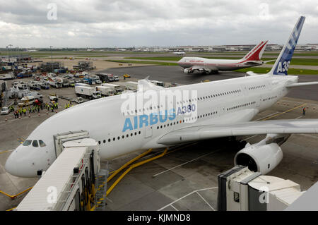 Parcheggiato a gate con jetway al Molo 6 terminale 3, la prima visita di un A380 per il Regno Unito, con jetway ed un Air India Boeing 747-400 rullaggio passato dietro Foto Stock