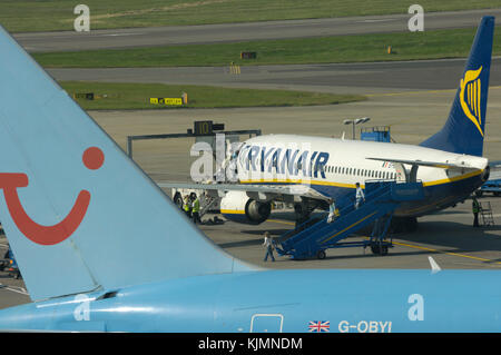 Coda, registrazione, Union Jack flag di Thomsonfly.com Boeing 767-300 ER e Ryanair con 737-800 Servisair airstairs parcheggiato sul piazzale dietro Foto Stock
