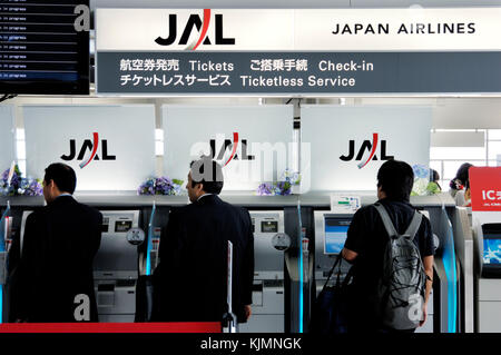 I passeggeri che utilizzano l'e-ticket, e-check-in self-service macchine in aeroporto principale dell'edificio del terminal. Foto Stock