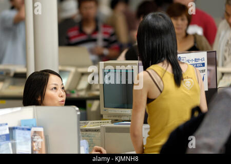 Passeggero e il bambino a ANA banco informazioni nella zona di check-in in aeroporto principale dell'edificio del terminal. Foto Stock