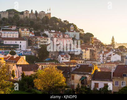 La soa jorge castle a Lisbona, Portogallo, con le case introno architettura, al tramonto. Foto Stock