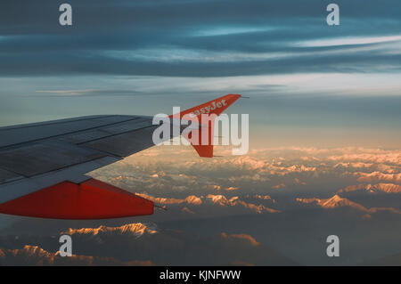 Easyjet ala di aeroplano che si affaccia alle cime innevate delle Alpi europee Foto Stock