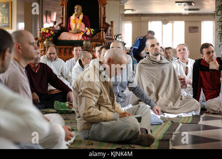 Gruppo di parrocchiani Krishna seduti su un pavimento e ascoltando guru in un tempio. Aprile 3, 2017. Tempio di Krishna, Kyiv, Ucraina Foto Stock