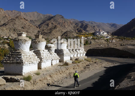 Ragazzo giovane passando gli stupa sulla strada per il monastero di Likir, Ladakh, Jammu e Kashmir in India. Foto Stock