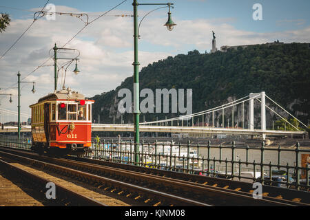 Un vintage red tram con la collina Gellert in background in Budapest (Ungheria). Giugno 2017. Formato orizzontale. Foto Stock