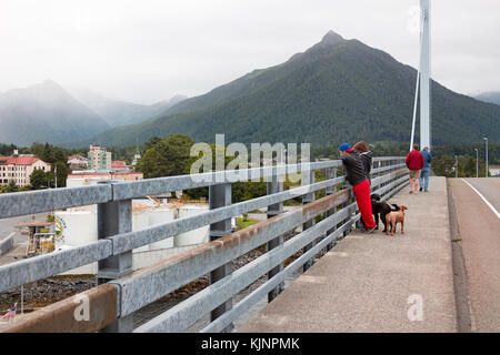 Sitka, Alaska, Stati Uniti d'America - 21 agosto 2017: le persone che cercano la vista sul marciapiede del John O'connell sospeso con cavi di bridge, sitka. Foto Stock