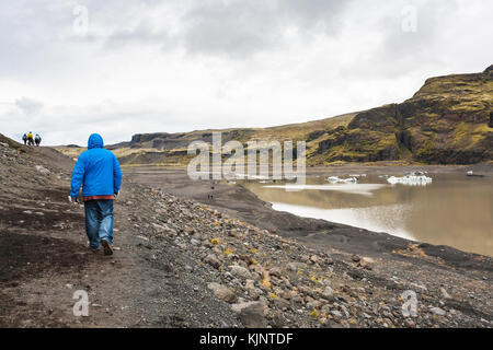 Viaggio in Islanda - i turisti escursione sul percorso dal ghiacciaio solheimajokull (sud lingua glaciale di myrdalsjokull tappo di ghiaccio) in katla geoparco in islandese a Foto Stock