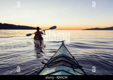 Kayak di mare nell'oceano durante una colorata e vivace tramonto. prese a Gerico, Vancouver, British Columbia, Canada. Foto Stock