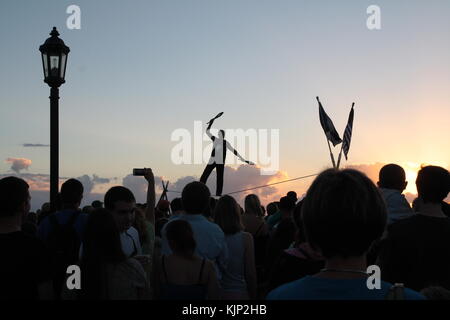 Acrobat camminando su un filo al tramonto in Mallory Square, key west, Florida. Foto Stock