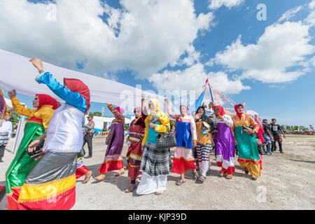 Tasto donne parata e eseguire la danza con colorati costumi tradizionali durante il wakatobi. wave festival. Foto Stock