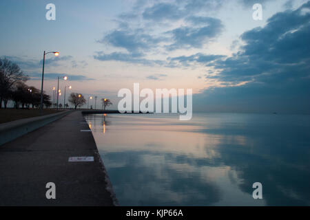 In un freddo inverno mattina, l'alba si rompe sul Lago Michigan litorale lungo North Avenue beach in Chicago, IL. Foto Stock