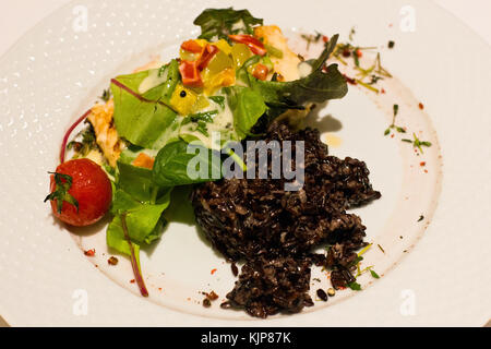 Brasato di riso nero con le verdure e rucola Foto Stock