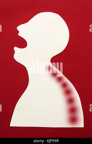 Concetto di essere umano diagnosi di malattia e dolore localizzazione su silhouette - simbolo astratto del corpo del paziente, dolore bruciante nella spina dorsale e aprì la bocca, isolato su sfondo rosso, vista dall'alto, piatto laici. Foto Stock