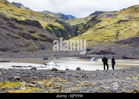 KALTA GEOPARK, ISLANDA - 9 SETTEMBRE 2017: Turisti vicino alla piscina di fusione del ghiacciaio Solheimajokull (lingua glaciale meridionale della calotta di ghiaccio Myrdalsjokull) a Ka Foto Stock