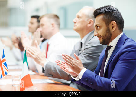 Gruppo di politici congratularmi con altoparlante dalle ovazioni dopo la relazione alla conferenza Foto Stock