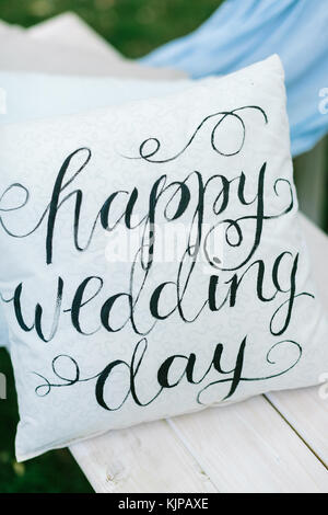 Sentimento, matrimonio, celebrazione concetto. è incantevole accessorio per la celebrazione di matrimoni all'aperto, Nizza cuscini bianchi con parole di congratulazione sulla panchina da giardino Foto Stock