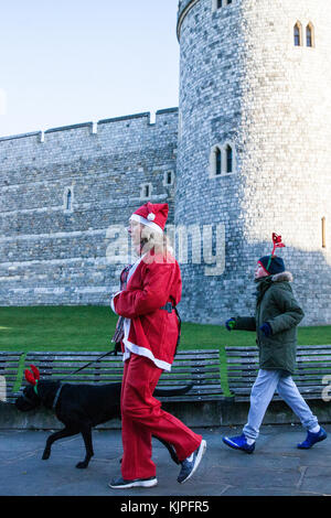 Windsor, Regno Unito. 25 novembre, 2017. corridori vestiti da Babbo Natale e la sua renna eseguire passato il castello di Windsor durante il 2017 santa dash in aiuto del Alexander devine ricovero per bambini. Credito: mark kerrison/alamy live news Foto Stock