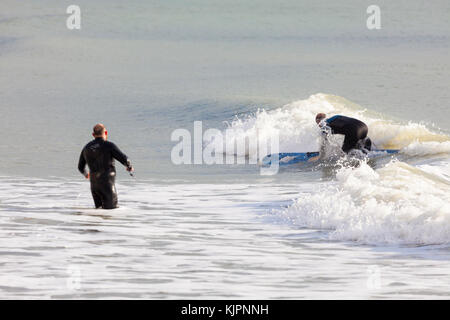 Hastings, East Sussex, Regno Unito. 28 Novembre, 2017. Clima mite in Hastings con un brivido leggero nell'aria, questo gruppo di paddle boarder paddle boarding prendere il mare in un po' di calma le condizioni Surf le piccole onde che sono in offerta. Photo credit: Paolo Lawrenson /Alamy Live News Foto Stock