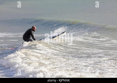 Hastings, East Sussex, Regno Unito. 28 Novembre, 2017. Clima mite in Hastings con un brivido leggero nell'aria, questo gruppo di paddle boarder paddle boarding prendere il mare in un po' di calma le condizioni Surf le piccole onde che sono in offerta. Photo credit: Paolo Lawrenson /Alamy Live News Foto Stock