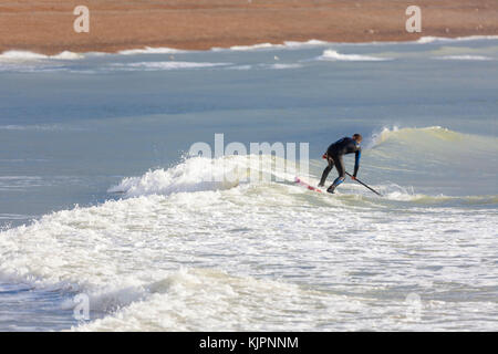 Hastings, East Sussex, Regno Unito. 28 Novembre, 2017. Clima mite in Hastings con un brivido leggero nell'aria, questo gruppo di paddle boarder paddle boarding prendere il mare in un po' di calma le condizioni Surf le piccole onde che sono in offerta. Photo credit: Paolo Lawrenson /Alamy Live News Foto Stock