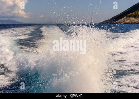 Sentiero dell'acqua la formazione di schiuma dietro un battello da crociera. costa dell'isola di Zante in background. Grecia. Foto Stock