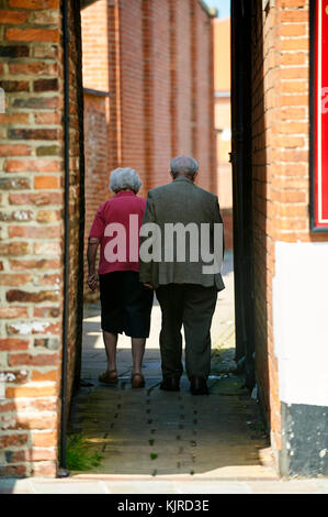 Titolare di pensione o di rendita giovane camminando tra tradizionali mattoni rossi vicolo, Beverley, East Yorkshire, Regno Unito Foto Stock