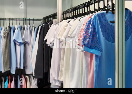 Le donne le camicette e le camicie sulla gruccia in negozio Foto Stock