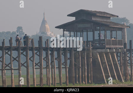 La popolazione locale attraversando il famoso U Bein's ponte di legno vicino a amarapura sul fiume irrawady, Myanmar (Birmania) Foto Stock