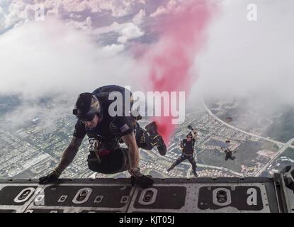 I soldati della squadra di paracadutisti della Marina degli Stati Uniti saltano dal retro di un aereo da trasporto C-130 Hercules della U.S. Air Force durante una dimostrazione di paracadute aerea per lo Stuart Air Show al Martin County Airport Witham Field 5 novembre 2017 a Stuart, Florida. (Foto di Kelsey L. Adams via Planetpix) Foto Stock