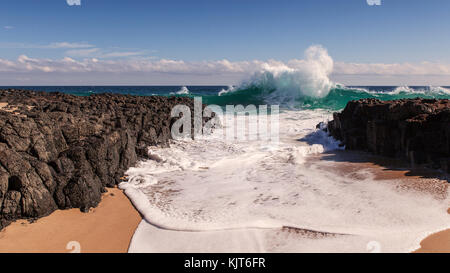 Aumento dell'onda vicino a terra prima che si infrangono sulle rocce Foto Stock