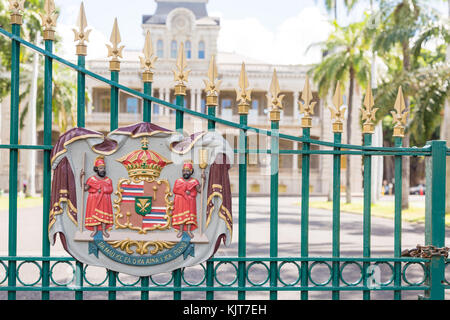 Emblema che mostra le popolazioni indigene e le insegne delle Hawaii presso il cancello del palazzo Iolani a Honolulu, Hawaii, Stati Uniti d'America Foto Stock