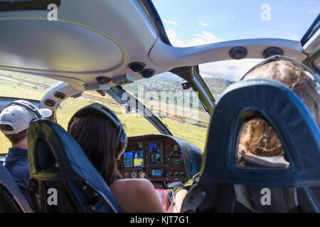 Tre persone in una cabina di elicotteri in volo sopra Kauai, Hawaii, Stati Uniti d'America Foto Stock