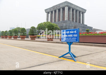 Segno blu per area riservata (NO) sconfinamenti in vietnamita e inglese dietro una linea gialla nella parte anteriore del mausoleo di Ho chi minh ad Hanoi, Vietnam Foto Stock